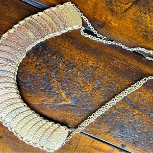 Gold-tone, hinged collar necklace.